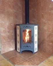 Недорогая печь-камин Бавария угловая с плитой незабудка Амазонка бай фото в интерьере в Гродно
