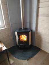 Недорогая печь-камин со стеклом Бавария угловая с плитой фото в интерьере в Гродно